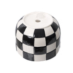 Inverted view of a round glossy ceramic planter with a black-and-white checkered design, showing base details.