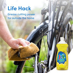 Outdoor life-hack style image showing someone cleaning a bicycle with a sponge and a Joy Ultra lemon dish liquid bottle inset at the corner