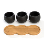 Three small textured black cement pots removed from tray and shown above the contoured bamboo stand on white background.