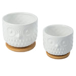 Pair of K‑Cliffs white owl planters shown from a slightly overhead angle with bamboo saucers beneath, photographed on white.