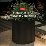 Graphite rattan-style cylinder planter with plant and text overlay reading 'Stands Up to All Weather Conditions'