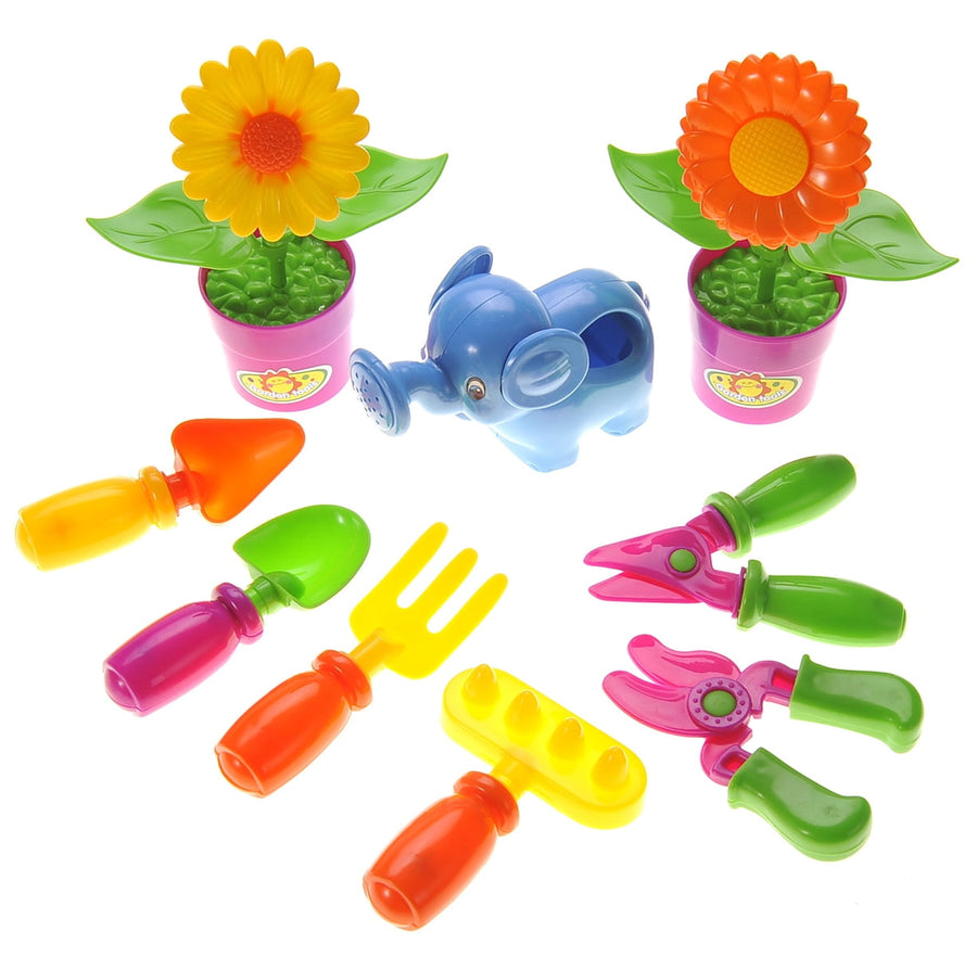 Assortment of colorful plastic children's gardening toys including two potted flowers, an elephant watering can and small hand tools on white.