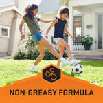 Two children playing soccer on a lawn above an orange banner that highlights the product's non-greasy formula