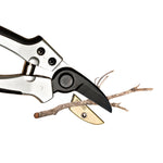 Close-up of Kings County Tools anvil pruning shears cutting a small dry twig on a white background