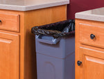 Tall rectangular kitchen trash can set between wood cabinets with a black trash bag liner visible