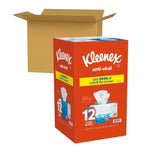 Kleenex anti-viral 12-cube outer carton pictured next to an open brown shipping box on a white background