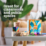 Decorative Kleenex Anti‑Viral cube box on a table in a classroom‑style scene with toys and text saying 'Great for classrooms and public spaces'.