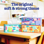 Three decorative Kleenex Trusted Care tissue boxes on a classroom desk with slogan above