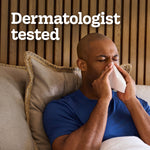 Man in bed holding a tissue to his nose with large text overlay saying 'Dermatologist tested'