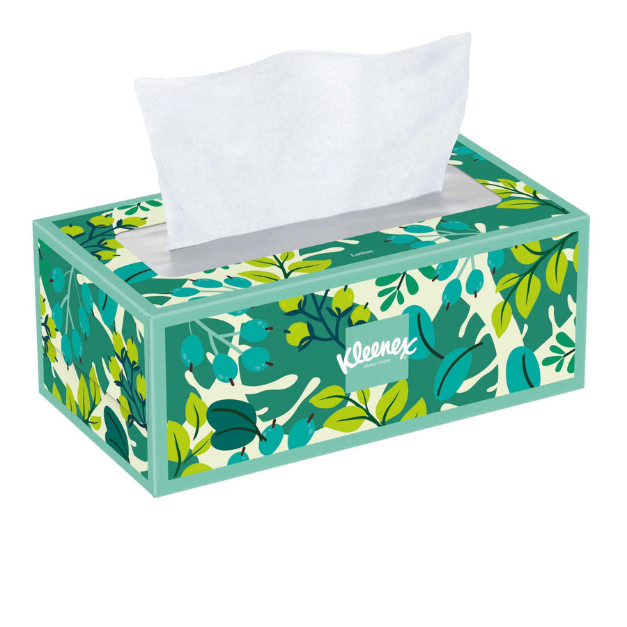 Single rectangular Kleenex tissue box with green leafy botanical pattern and one tissue partially pulled out.