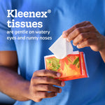 Close-up of hands dispensing a tissue from a colorful Kleenex slim wallet pack with headline about being gentle on watery eyes