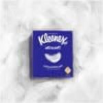 Small, slightly blurred thumbnail of a Kleenex Ultra Soft purple cube box on a light textured background