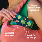 Person placing a Kleenex slim wallet tissue pack with green floral and koi design into a pink purse, infographic callouts