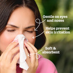 Woman holding a tissue to her nose with callouts reading 'Gentle on eyes and noses' and 'Soft & absorbent'.