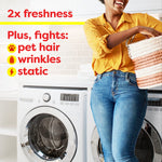Lifestyle image of a smiling person holding a laundry basket with text listing 2x freshness and fights pet hair, wrinkles, static