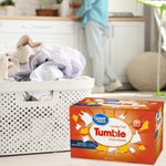 Laundry scene with a white perforated laundry basket and a box of Great Value Tumble dryer sheets placed on the floor in front of a blurred kitchen background.
