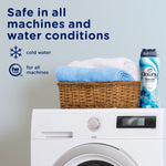 Laundry room scene with stacked towels in a basket, a washing machine and a Downy Blends bottle with safety text