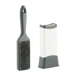 Gray-handled double-sided lint remover brush alongside its white and gray self-cleaning base