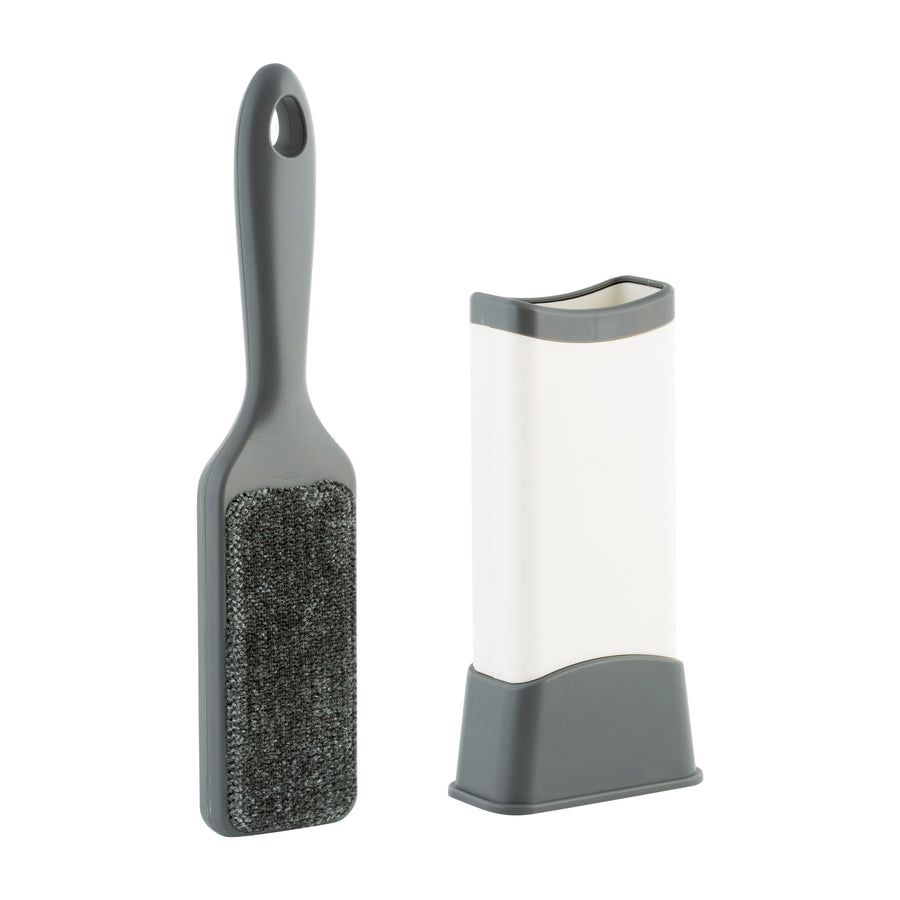 Gray-handled double-sided lint remover brush alongside its white and gray self-cleaning base