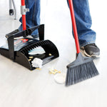 Lifestyle shot of Libman broom sweeping debris into a matching dustpan while a person stands nearby in jeans