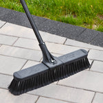 Close-up of Libman broom head and handle on pavers highlighting textured head and black bristles