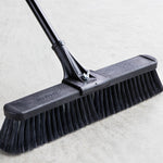 Detailed studio close-up of Libman broom head showing molded plastic top, metal handle mount and black bristles
