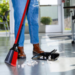 Person sweeping popcorn on tiled floor with Libman red-handled broom and separate black dustpan nearby