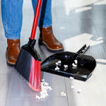 Close lifestyle shot of Libman red-handled angle broom sweeping popcorn toward a black dustpan on tile