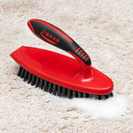 Libman red scrub brush with black bristles shown cleaning a light carpet with visible foam