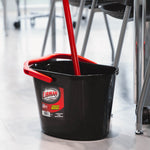 Libman black utility bucket with red handle in a room setting, a mop handle placed inside the bucket
