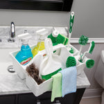 Libman white plastic caddy set on a bathroom counter filled with spray bottles, brushes, dustpan and microfiber towels