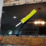 Microfiber chenille duster held on a pole across the surface of a large flat screen TV reflecting room lights