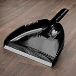 Close-up of a black Libman High Power dustpan on a wood floor showing rubber lip
