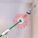 Libman spin mop head attached to handle leaning against a tiled shower wall, orange and white strips visible