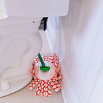 Spin mop head with orange and white patterned strips positioned beside a toilet bowl on a bathroom floor