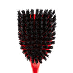 Close-up top-down view of dense black bristles on a red Libman scrub brush