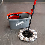 Libman spin mop and gray bucket set with red accents, mop head installed and resting on a gray floor surface