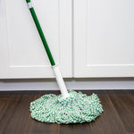 Libman green-and-white twist mop head and green handle resting on dark wood floor