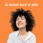 Smiling person against an orange background with headline ‘an instant burst of ahhh’, lifestyle image for Febreze Tropical Blend