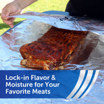 Person lifting aluminum foil to reveal a rack of glazed ribs resting on foil outdoors