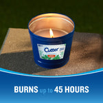 Lit Cutter blue outdoor candle in a metal-lined tub on a concrete surface with burn time claim banner.