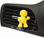 Yellow Little Joe smiling vent-clip attached to a car air vent demonstrating in-vehicle placement