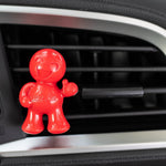 Close-up of red Little Joe character air freshener clipped to a car AC vent