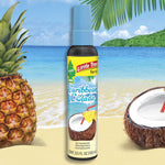 Little Trees Caribbean Colada spray bottle staged on a beach scene with pineapple, coconut halves and palm leaves.