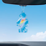 Little Trees Fire Rainbow air freshener hanging from rearview mirror against a clear sky backdrop