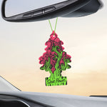 Little Trees Sour Power air freshener hanging from a rearview mirror inside a car, showing pink and green tree-shaped design