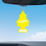 Yellow Little Trees Vanillaroma air freshener hanging from a rearview mirror against a blue sky