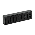 Black rectangular Lodge rust eraser bar with raised LODGE lettering on a white background