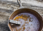 Rusty cast-iron skillet with a Lodge rust eraser bar resting inside, showing embossed LODGE logo