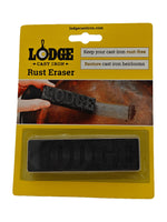Yellow blister pack front showing Lodge Rust Eraser in plastic tray and a hand using the eraser on a pan